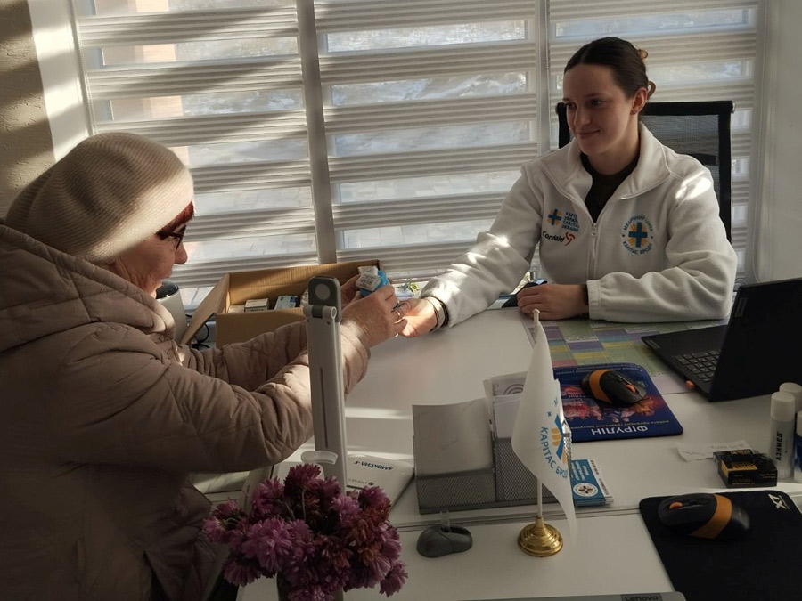 Ärztin reicht einer Patientin Medikamente