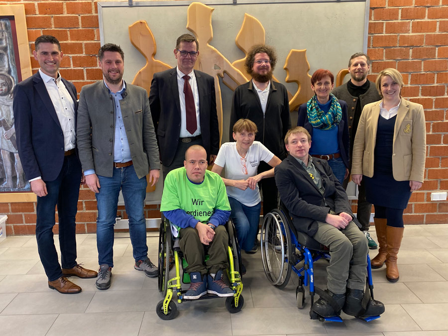 Ein Gruppenbild mit allen Beteiligten an der Podiumsdiskussion in den Straubinger Werkstätten: vorne von links: Werkstattrat Alex Temmel, Werkstatträtin Erika Stelzl, Sebastian Müller, Leiter des Büros für Leichte Sprache der KJF Regensburg. hintere Reihe, von links: Andreas Liebl, Freie Wähler, Andreas Aichinger, CSU, Oskar Saller, SPD, Markus Beck, Vertrauensperson des Werkstattrats, Evi Feldmeier, Geschäftsführerin der KJF Werkstätten gGmbH, Mario Franz, Leiter des Fachdiensts für Leichte Sprache, Melanie Eibl, Geschäftsführerin der KJF Werkstätten gGmbH