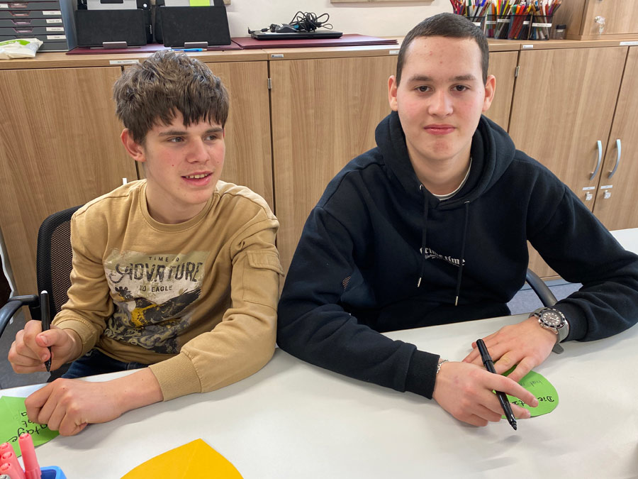 Zwei Schüler des Cabrini-Zentrums beim Erstellen des Plakats.