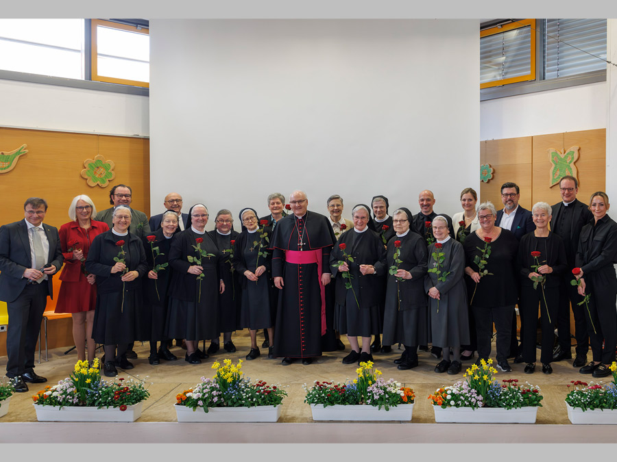 Gruppenbild mit Kreuzschwestern, die eine rote Rose halten