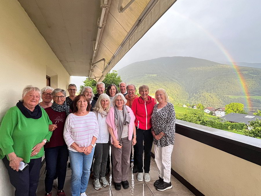 Exerzitiengruppe auf Balkon im Hintergrund ein Regenbogen