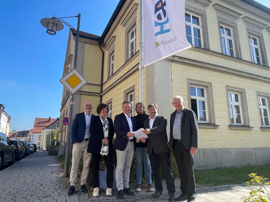 Gruppenbild vor der Fachschule für Heilerziehungspflege in Erbendorf mit Stellvertretender Direktor der KJF Hans Horn, Einrichtungsleiterin WG St. Benedikt Elke Bauer, MdL Tobias Reiß, Schulleiterin Alexandra Mozelewski, KJF-Direktor Michael Eibl, Vorsitzender des bbz e. V. Johannes Reger