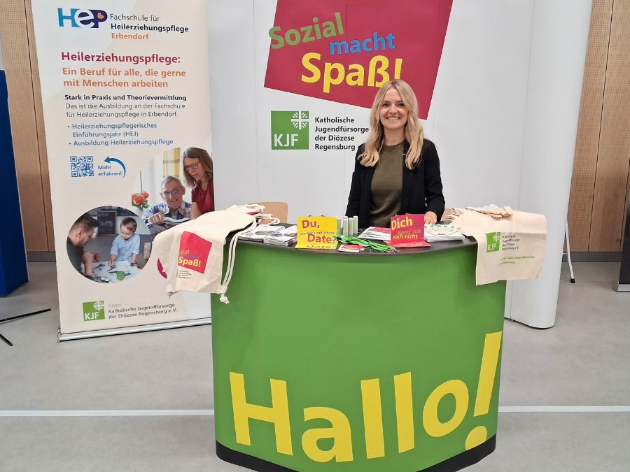 Mitarbeiterin der KJF steht vor dem Messestand auf der Ausbildungsmesse in Kemnath.