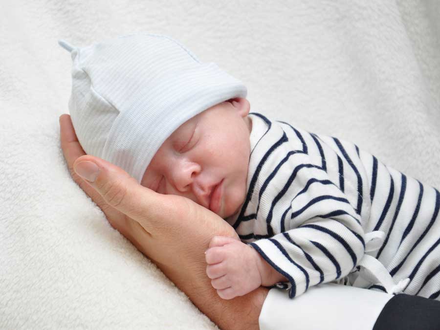 Schlafendes Baby von Hand gehalten