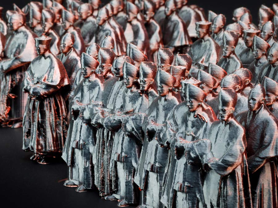 Eine Gruppe von Geistlichen, die man an ihrer Kleidung und Kopfbedeckung erkennt. Es sind Bischöfe und Kardinäle. Die Darstellung ist ein Kunstwerk aus dem 3-D-Drucker.